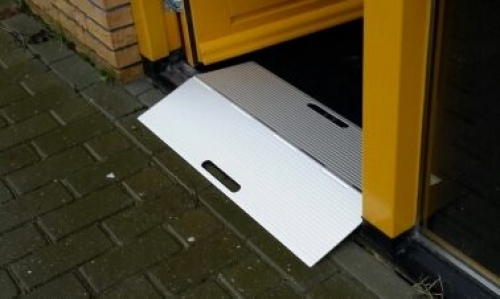 Meeneembare aluminium drempelhulp bij een buitendeur